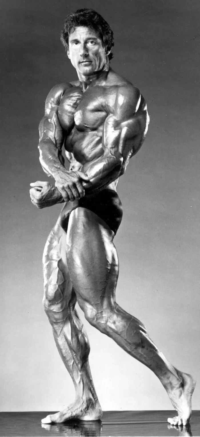A crisp, well-lit black-and-white studio side-triceps lunge with classic Golden-Era aesthetic.