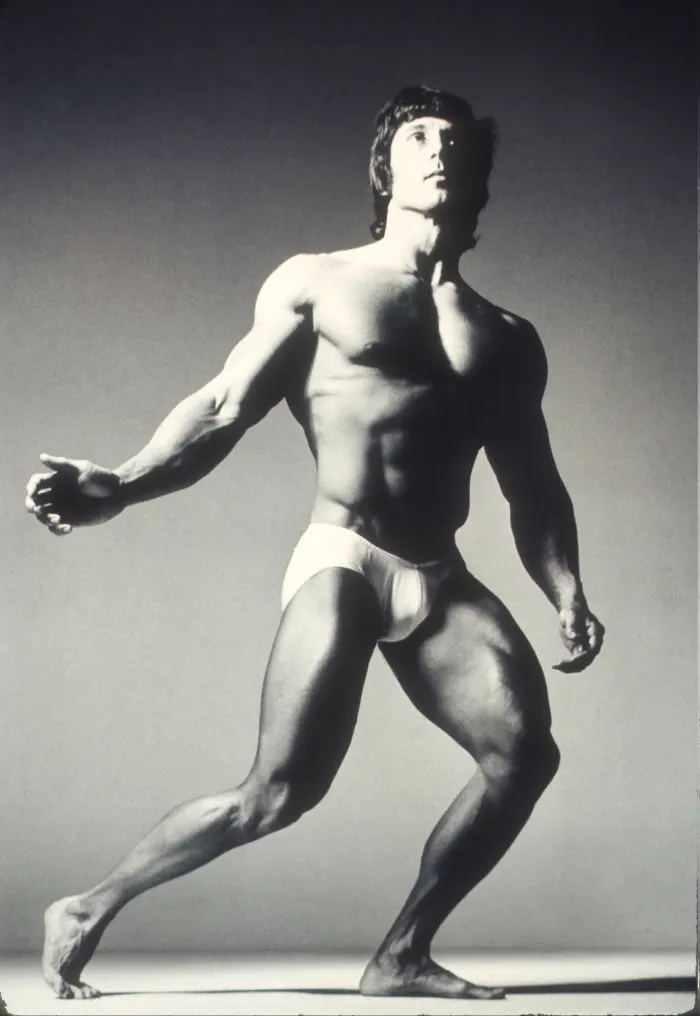 A dramatic low-angle black-and-white lunge pose with dynamic negative space and strong studio lighting.